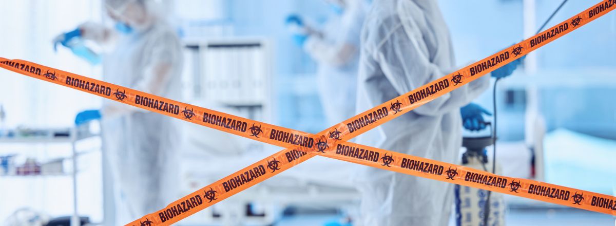 Biohazard tape sealing off area being cleaned by specialist cleaners in hazmat suits
