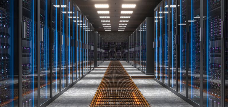 View down a data centre aisle showing rows of servers and the grilled flooring