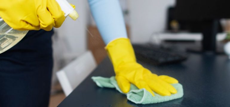 Technician spraying desk with cleaner