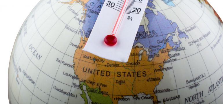 A thermometer pinned to a globe on the United States, indicating rising temperatures.