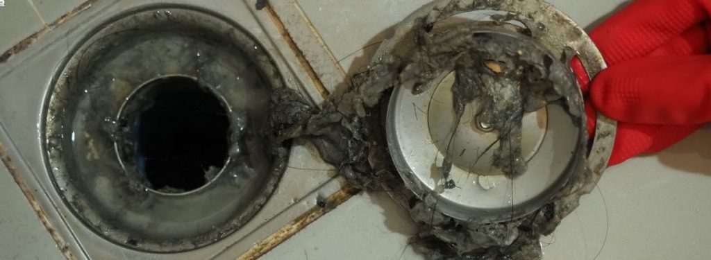 Bathroom shower drain blocked from buildup producing odours