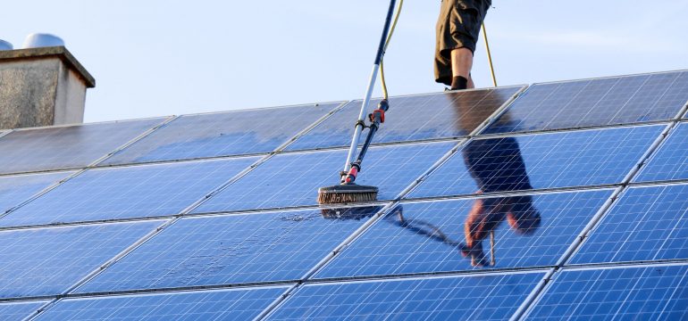 Technician Cleaning Solar Panels
