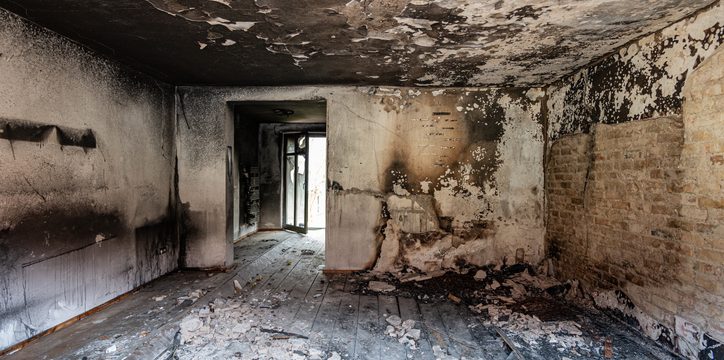 Commercial interior exhibiting secondary fire damage, including acidic soot buildup on walls and ceiling corrosion requiring professional remediation